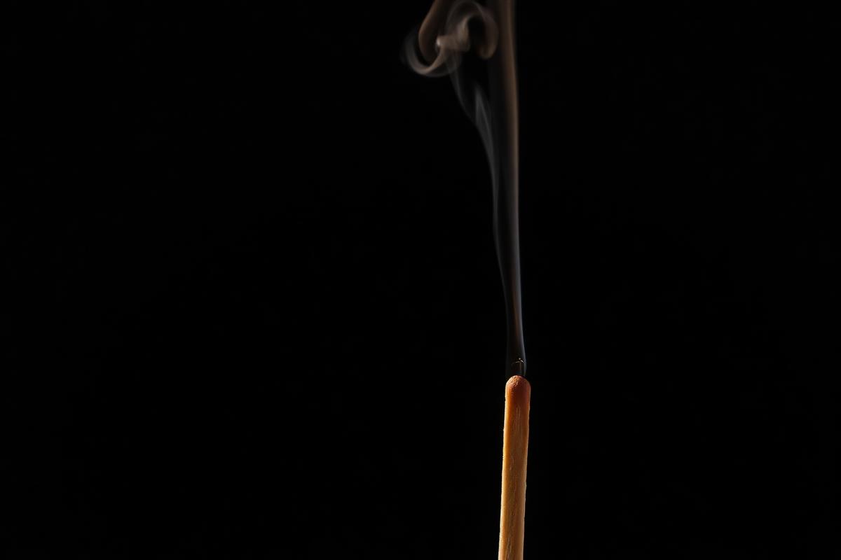 A just-extinguished match with a thin trail of smoke